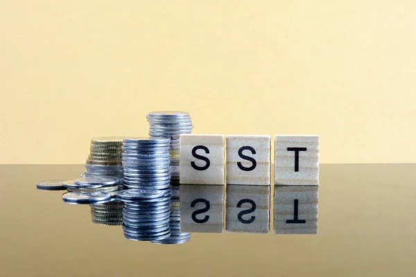 TAX CONCEPT. Sales & Service Tax word from wood plate and stacked of coins.
