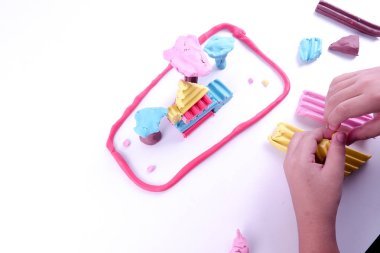 Çocuk elleri renkli kille oynuyor.