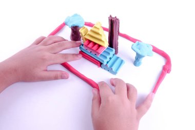 Çocuk elleri renkli kille oynuyor.