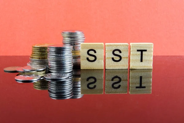 TAX CONCEPT. Sales & Service Tax word from wood plate and stacked of coins.
