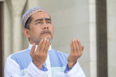 Orta yaş Müslüman erkek camide dua.