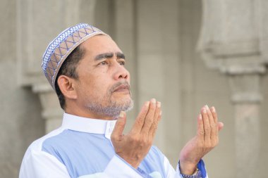 Orta yaş Müslüman erkek camide dua.