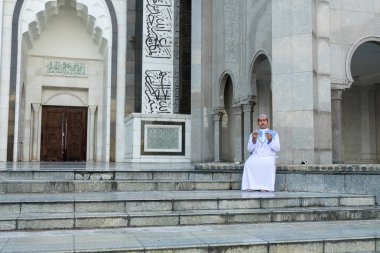 Middle age muslim man praying at mosque. clipart