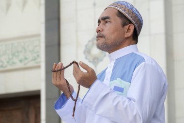 Orta yaş Müslüman erkek camide dua.