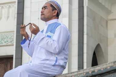 Orta yaş Müslüman erkek camide dua.