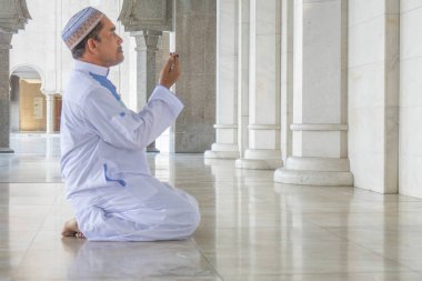 Middle age muslim man praying at mosque. clipart