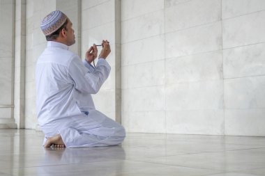 Orta yaş Müslüman erkek camide dua.