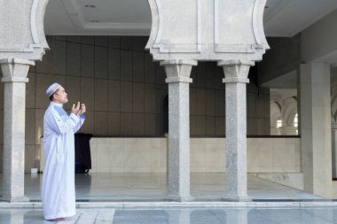 Middle age muslim man praying at mosque. clipart