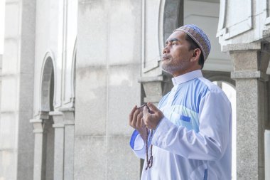 Orta yaş Müslüman erkek camide dua.