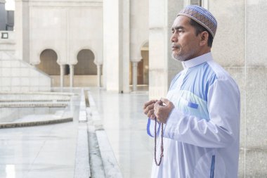 Orta yaş Müslüman erkek camide dua.