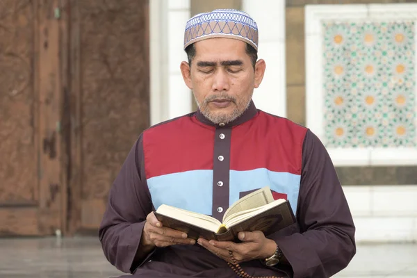 Middle age muslim man praying at mosque.