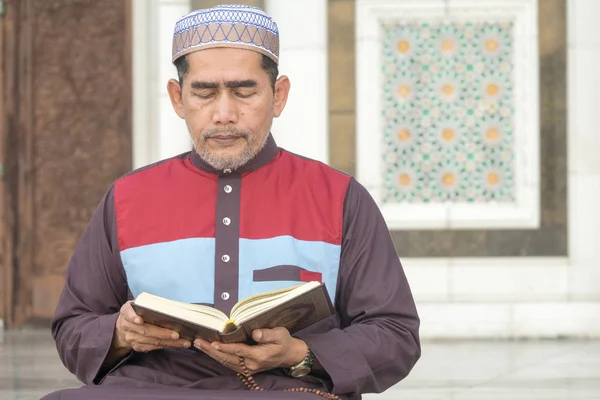 Middle age muslim man praying at mosque.