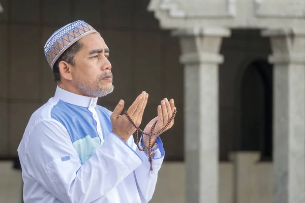 Middle age muslim man praying at mosque.