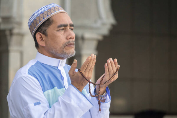 Middle age muslim man praying at mosque.