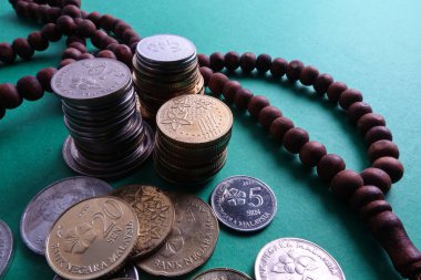 İslami bankacılık/finansman kavramsal tespih ve yeşil bir arka plan üzerinde para ile.