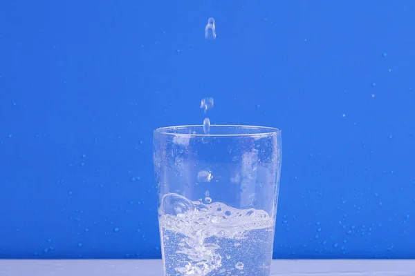 Voda Stříkající Skla Izolovány Modrém Pozadí — Stock fotografie