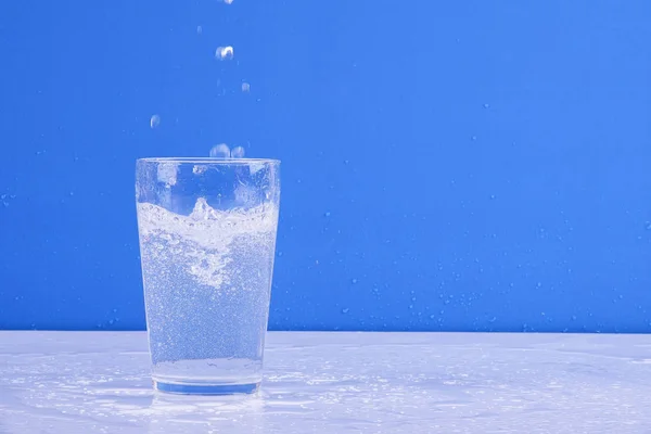 Éclaboussures Eau Verre Isolé Sur Fond Bleu — Photo