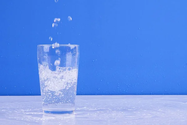 Salpicos Água Vidro Isolado Fundo Azul — Fotografia de Stock