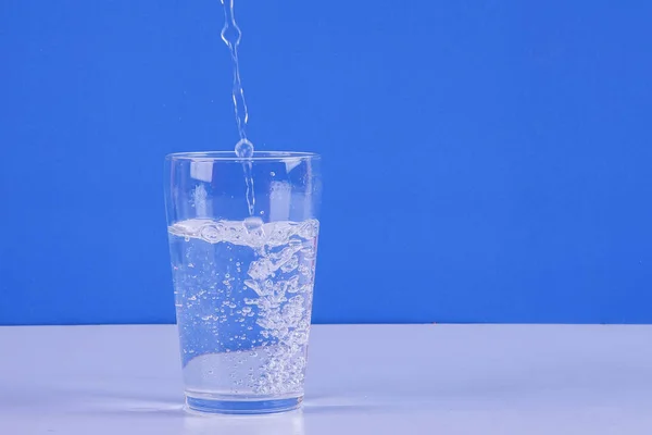 Salpicaduras Agua Vidrio Aislado Sobre Fondo Azul —  Fotos de Stock