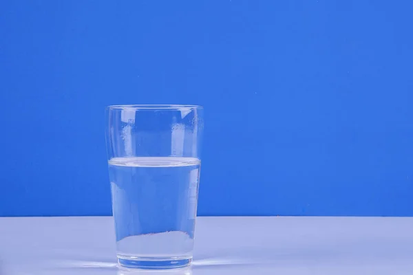 Vatten Stänk Från Glas Isolerade Blå Bakgrund — Stockfoto