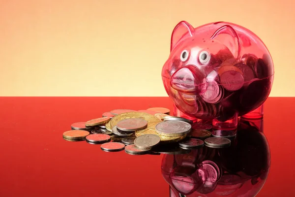 SAVING CONCEPT: A red piggy bank on a orange background.