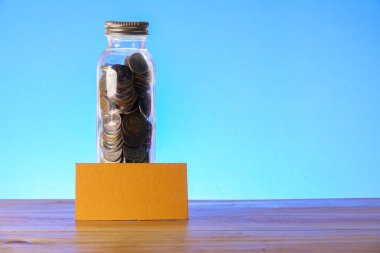 Kavram mason kavanoza, sikke ve kumbara ile mavi bir arka plan üzerinde kaydetme.