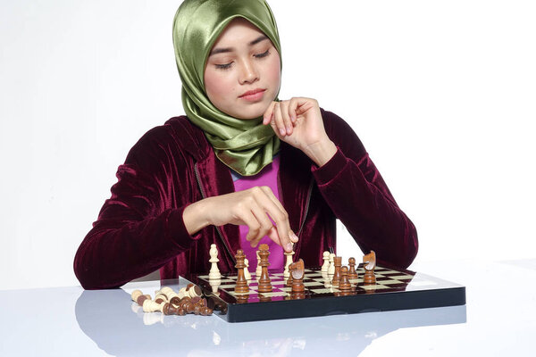Портрет красивой завуалированной молодой женщины, улыбающейся, играющей в шахматы
