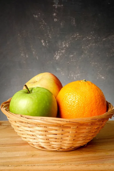 An orange and apples over grunge black background