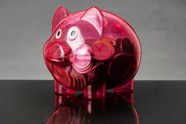 Red piggy bank on a rustic black background.