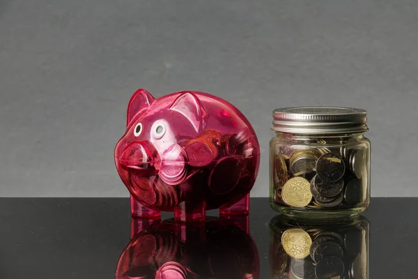 Red piggy bank on a rustic black background.