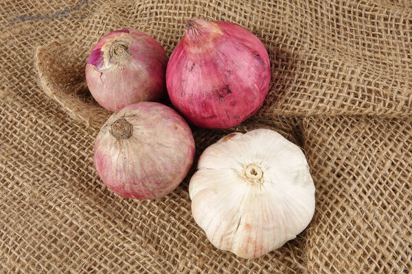 Onions on a brown rug background.