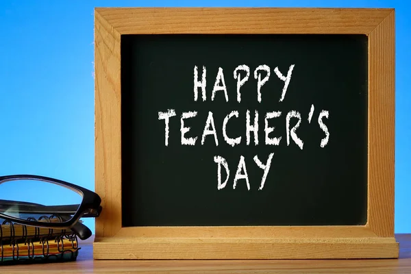 HAPPY TEACHER\'S DAY CONCEPT: School stationeries over a blue background.