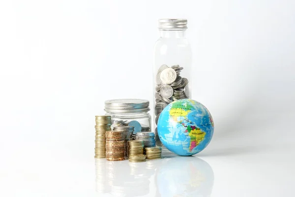 全球经济概念与球体球和硬币堆积在白色 — 图库照片