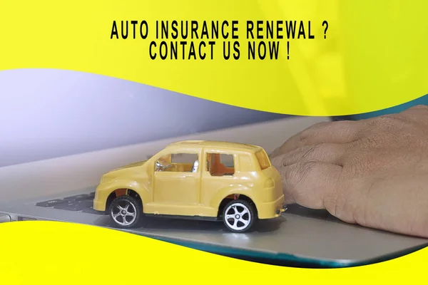 Auto insurance conceptual with small yellow car model on a laptop.