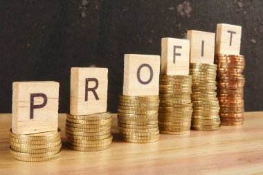 İş kavramı üzerine zam trend ahşap plaka üzerinde kar Word'le sikkeleri yığılmış.