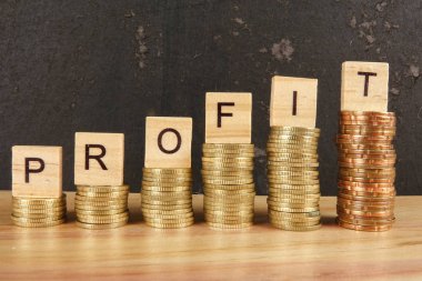 İş kavramı üzerine zam trend ahşap plaka üzerinde kar Word'le sikkeleri yığılmış.