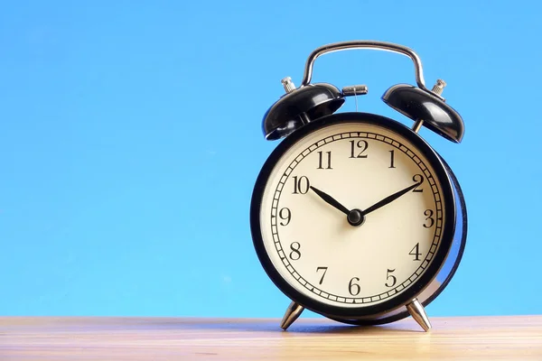 Black Alarm Clock Wooden Surface Blue Background — Stock Photo, Image