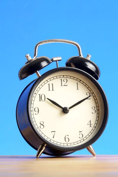 Black Alarm Clock Wooden Surface Blue Background — Stock Photo, Image
