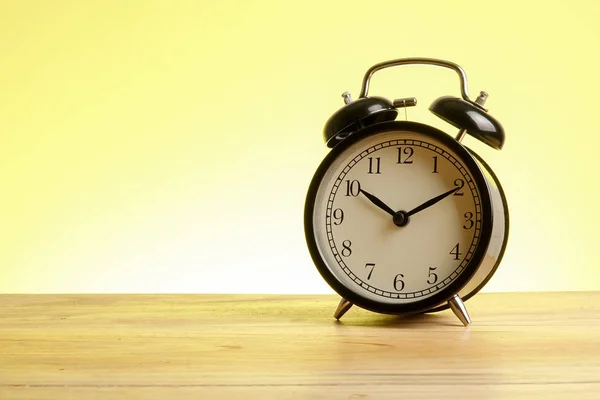 Reloj Despertador Negro Superficie Madera Contra Fondo Amarillo —  Fotos de Stock