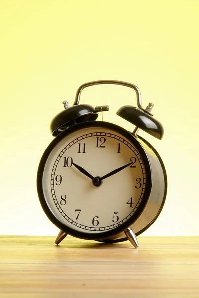 Reloj Despertador Negro Superficie Madera Contra Fondo Amarillo —  Fotos de Stock