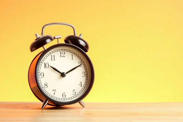 Reloj Despertador Negro Superficie Madera Contra Fondo Amarillo — Foto de Stock