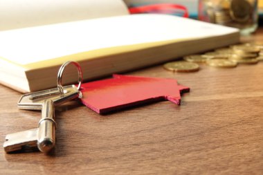 Kırmızı küçük ev ve çelik anahtar ile mülkiyet / konut mülkiyet kavramı.