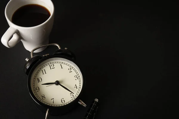 コーヒータイムコンセプト コーヒーカップと目覚まし時計付きのオフィスレザーデスクテーブル コピースペース付きのトップビュー — ストック写真
