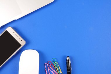 Mavi arka plan üzerinde ofis staioneries üst görünümü.