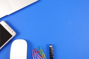 Mavi arka plan üzerinde ofis staioneries üst görünümü.