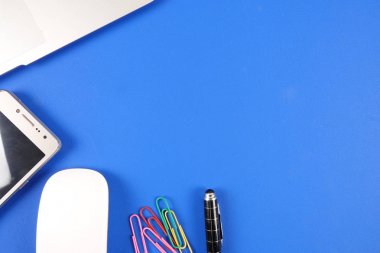 Mavi arka plan üzerinde ofis staioneries üst görünümü.