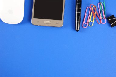 Mavi arka plan üzerinde ofis staioneries üst görünümü.