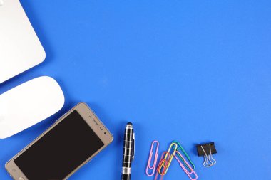 Mavi arka plan üzerinde ofis staioneries üst görünümü.