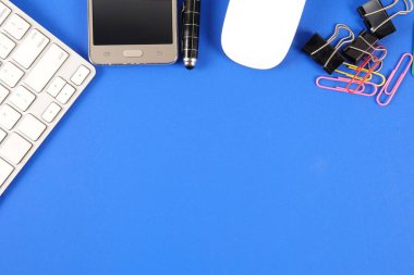 Mavi arka plan üzerinde ofis staioneries üst görünümü.