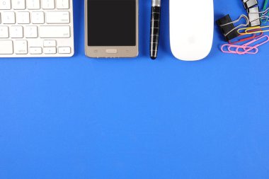 Mavi arka plan üzerinde ofis staioneries üst görünümü.
